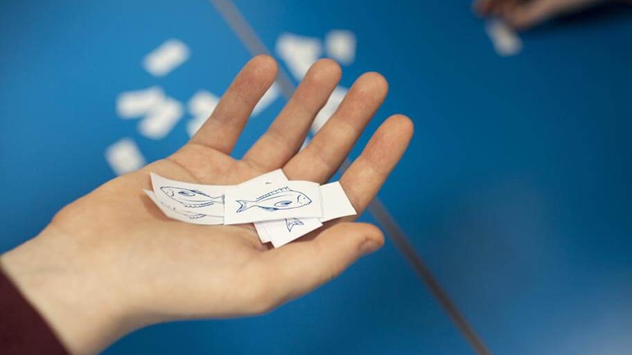 Ocean literacy A student learning about ocean literacy. Their hand is holding a cut out of a paper fish.